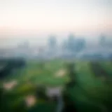 Aerial view of the lush green fairways at Dubai Golf Club with the skyline in the background